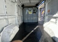 Interior view of a white cargo van with black floor and metal partition.