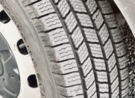 Close-up of a winter tire tread with deep grooves for traction.