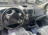 Ford Transit van dashboard with steering wheel, gear shifter, and center console.