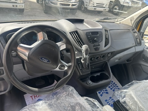Ford Transit van dashboard with steering wheel, gear shifter, and center console.