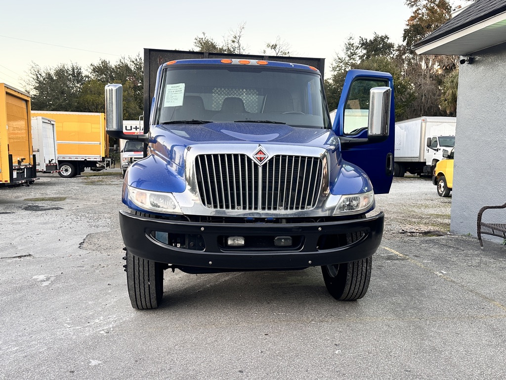 Blue International box truck with a chrome grille and open driver's door