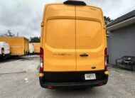 Rear view of a yellow Ford Transit van with license plate TAX7172.