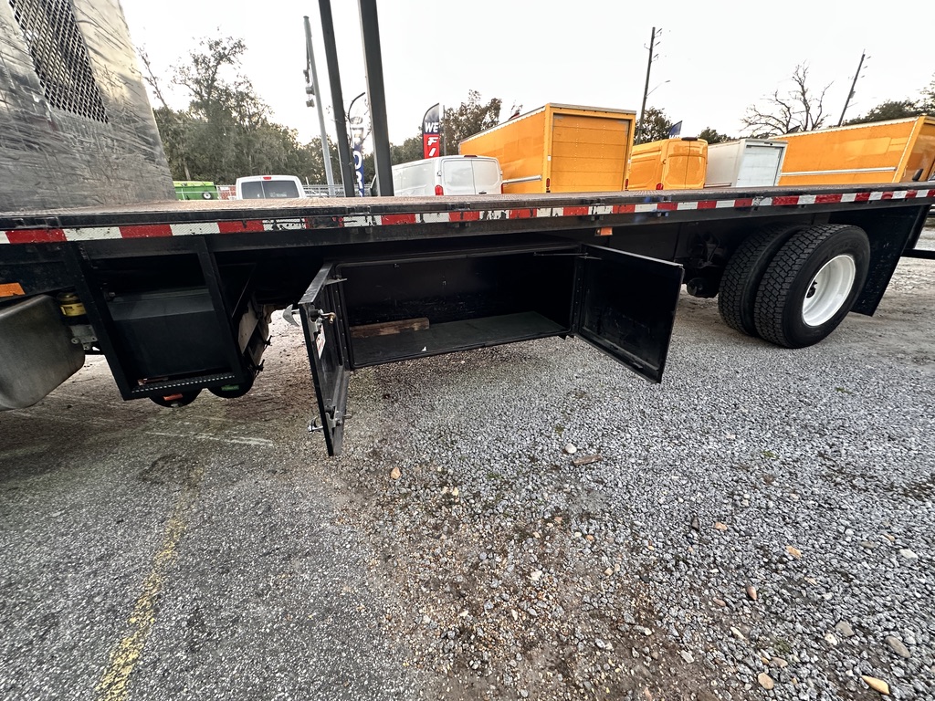 Flatbed truck with open storage compartments and dual rear wheels