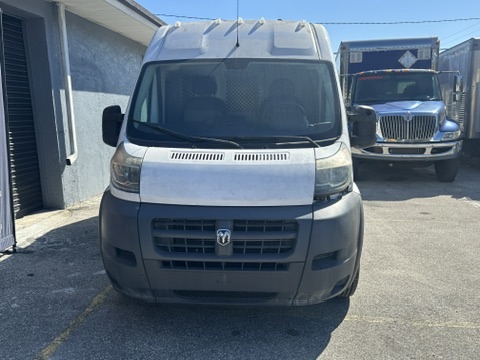 White Ram ProMaster van parked outdoors with a blue truck in the background.