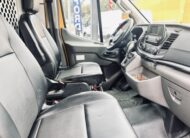 Interior view of a van's driver and passenger seats, dashboard, and steering wheel.