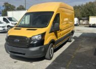 Yellow Ford Transit van parked on asphalt lot