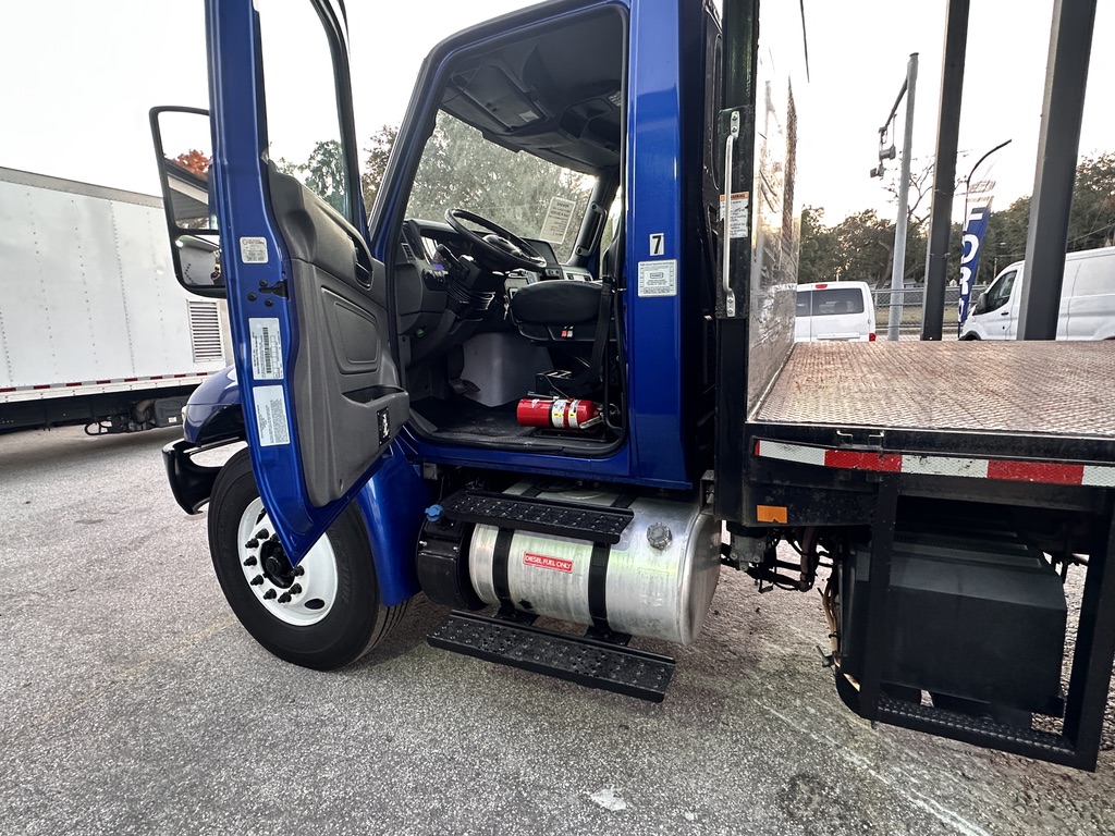 Blue flatbed truck with open door, showing interior and fuel tank.
