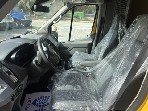 Interior of a yellow van with plastic-covered seats and dashboard.
