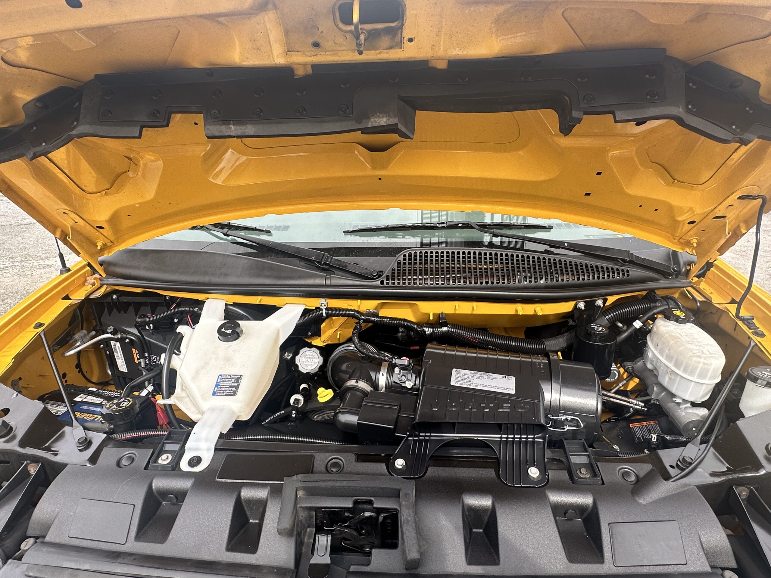 2020 GMC Savana 3500 engine bay, yellow hood open, showing components.