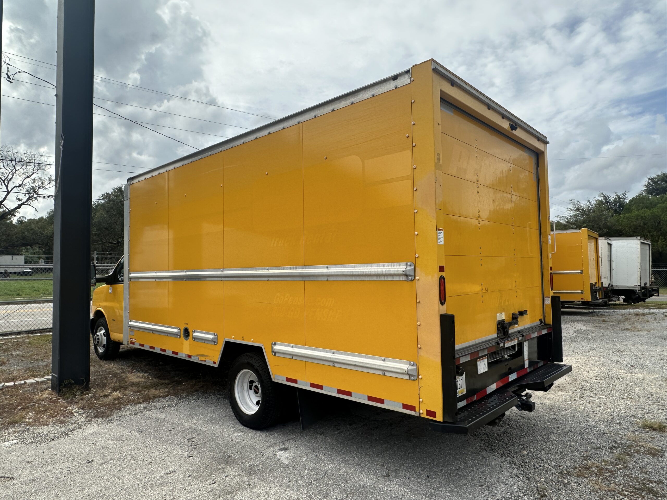 Rear view of a yellow 2020 GMC Savana 3500 16ft box truck.