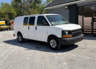 2009 white Chevy G2500 cargo van parked outside a U-Haul location.