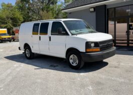 2009 white Chevy G2500 cargo van parked outside a U-Haul location.