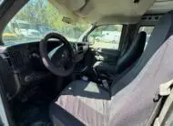 Interior view of a 2009 Chevy G2500 cargo van, showing seats and dashboard.
