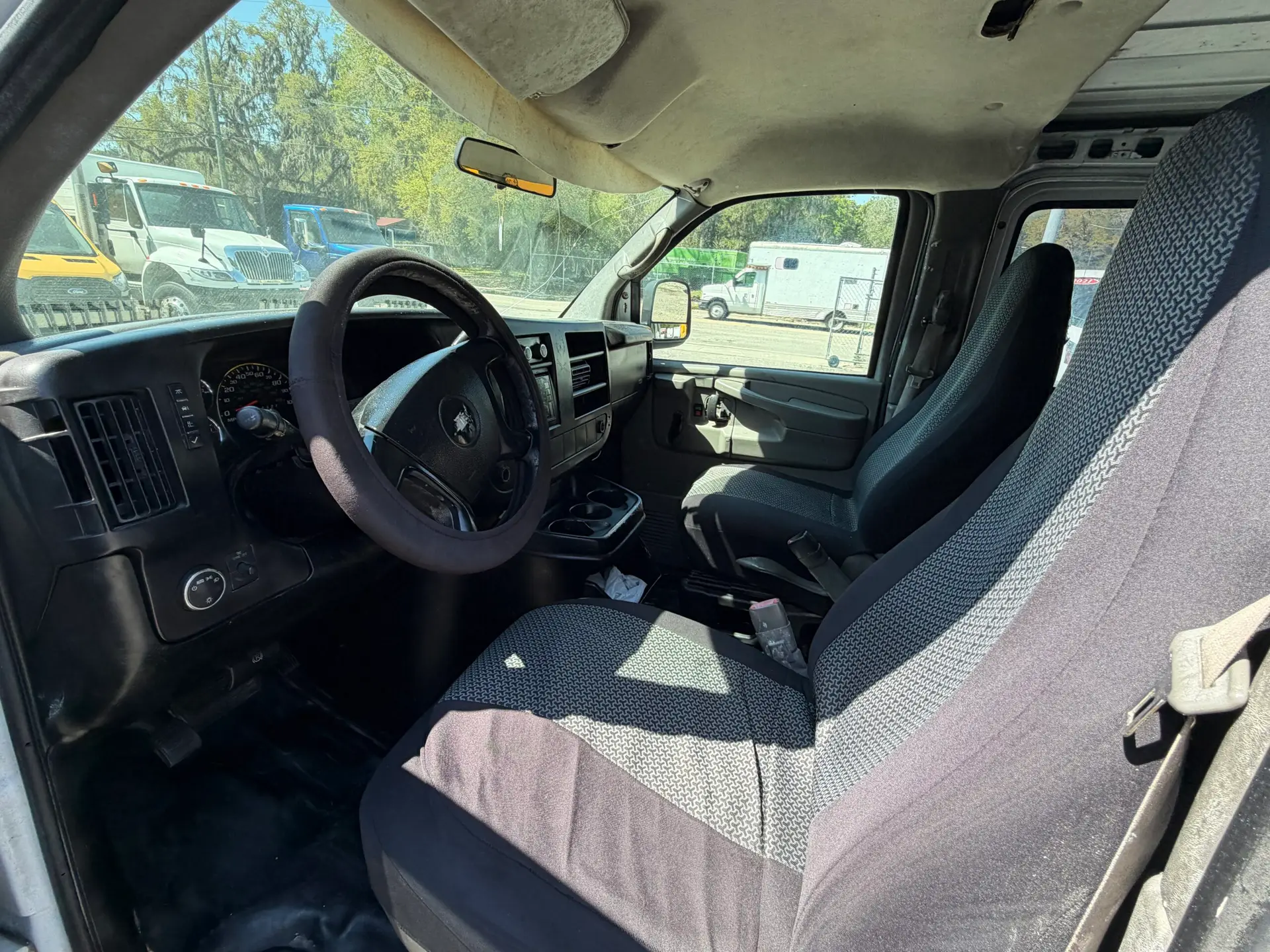 Interior view of a 2009 Chevy G2500 cargo van, showing seats and dashboard.