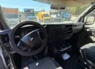 2009 Chevy G2500 cargo van interior, dashboard, steering wheel, and cup holders.