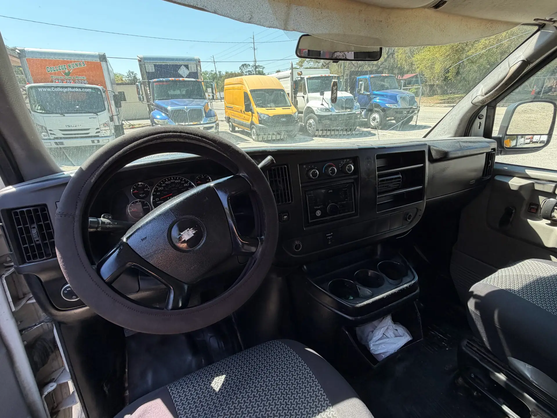 2009 Chevy G2500 cargo van interior, dashboard, steering wheel, and cup holders.