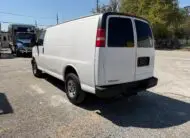 Rear view of a white 2009 Chevy G2500 cargo van parked outdoors.