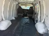 Interior of a 2009 Chevy G2500 cargo van, showing empty cargo space and front seats.