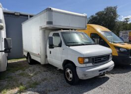 White Ford E-Series box truck parked next to a yellow U-Haul van