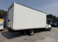 White box truck parked on gravel lot with blue truck in background.