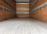 Interior of an empty truck cargo bay with wooden floor and walls.