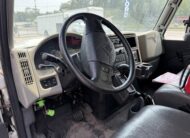 Interior of a commercial truck cab, showing the steering wheel, dashboard, and driver's seat.