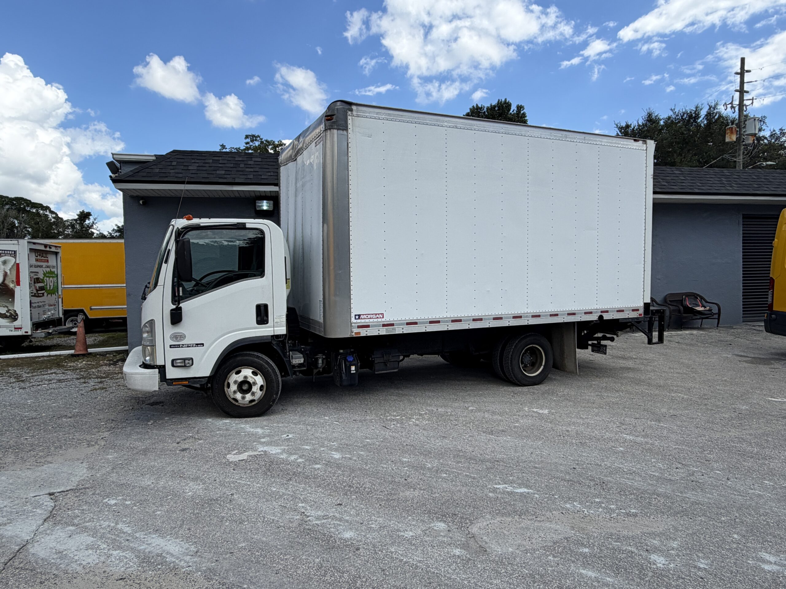 2019 Isuzu NQR 16ft diesel box truck with liftgate parked outdoors.