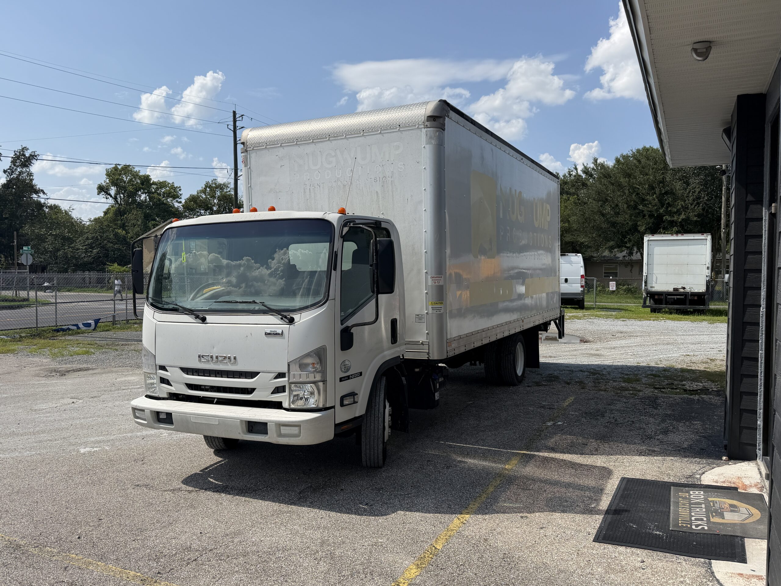 2020 Isuzu NRR 20ft. box truck with liftgate parked outside.