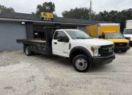 2019 Ford F-550 stake body truck parked outside a dealership