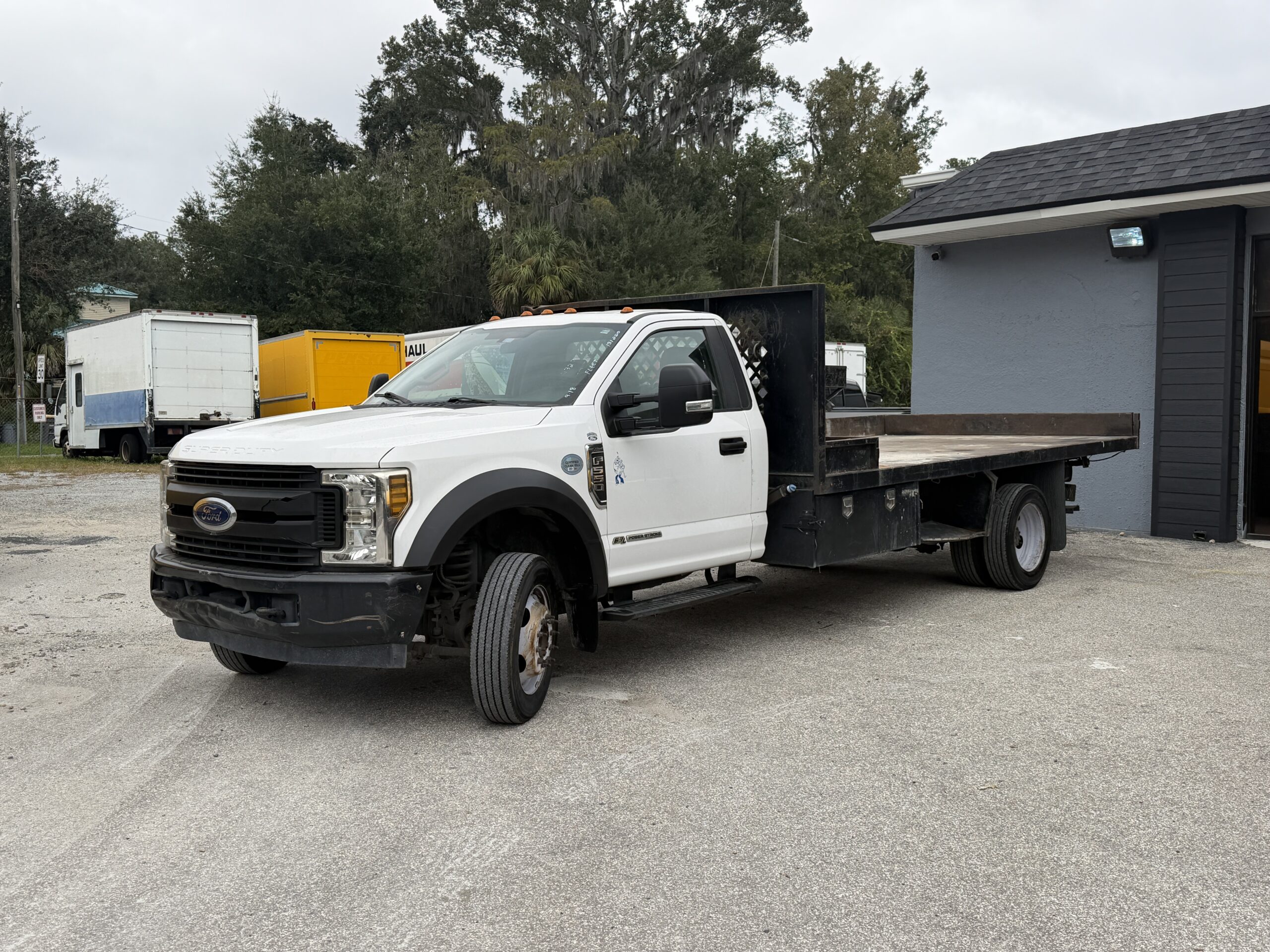 White 2019 Ford F-550 stake body truck with flatbed