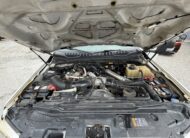 2019 Ford F-550 stake body with 6.7L PowerStroke diesel engine exposed.