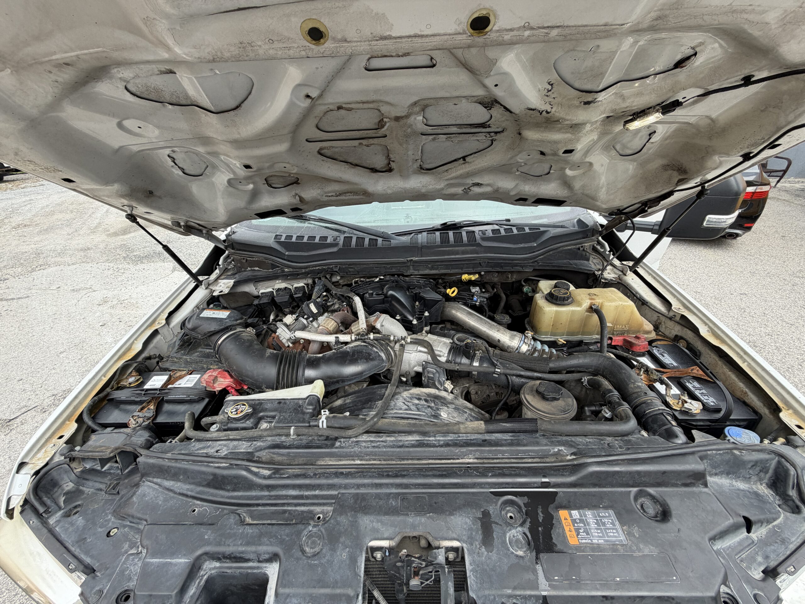 2019 Ford F-550 stake body with 6.7L PowerStroke diesel engine exposed.