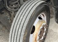 Close-up of a 2019 Ford F-550 stake body truck tire and rusty wheel